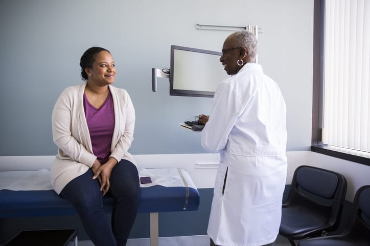 Photo shows a doctor speaking with her patient/Getty Images