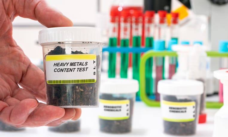 Photo shows a soil sample in a plastic container labeled 'heavy metals content test'/Getty Images