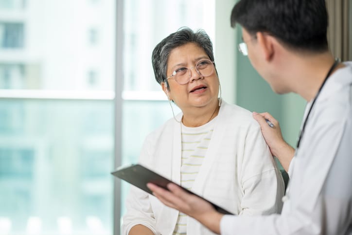 Photo shows a patient speaking with her doctor/Getty Images