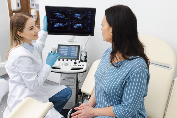 Photo shows a doctor and patient discussing the results of an ultrasound examination of uterus and ovaries at the gynecologist office in a modern clinic/Getty Images