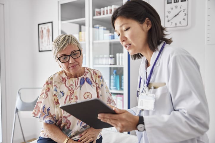 Photo shows a doctor speaking with her female patient/Getty Images