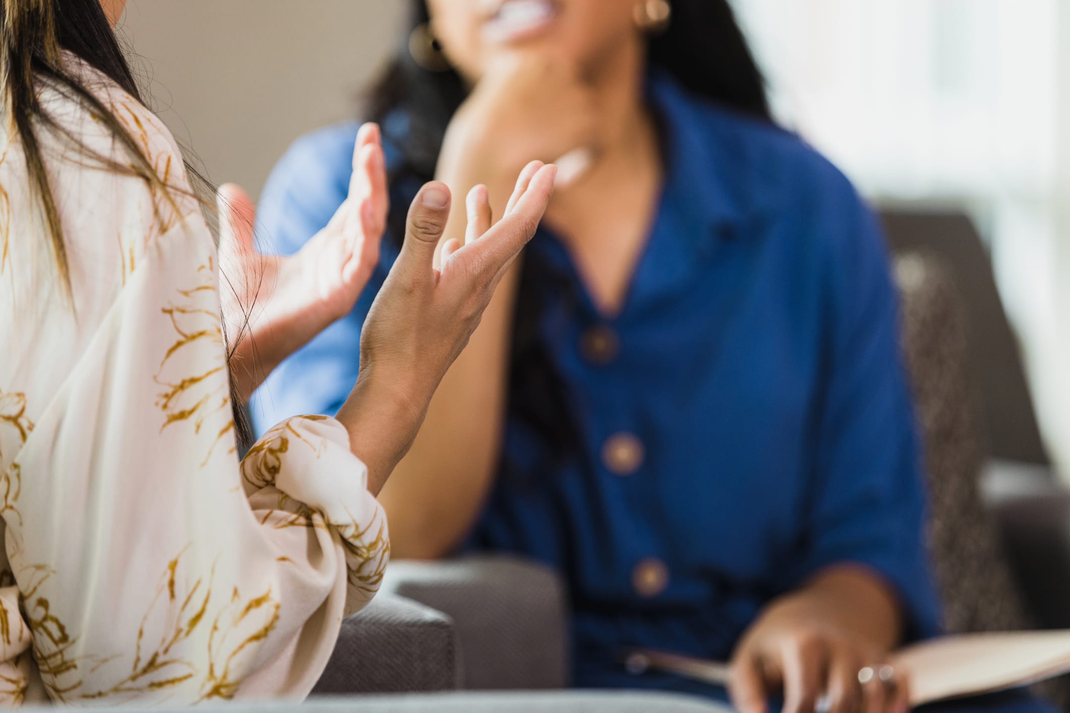 A woman gesturing while talking with a friend