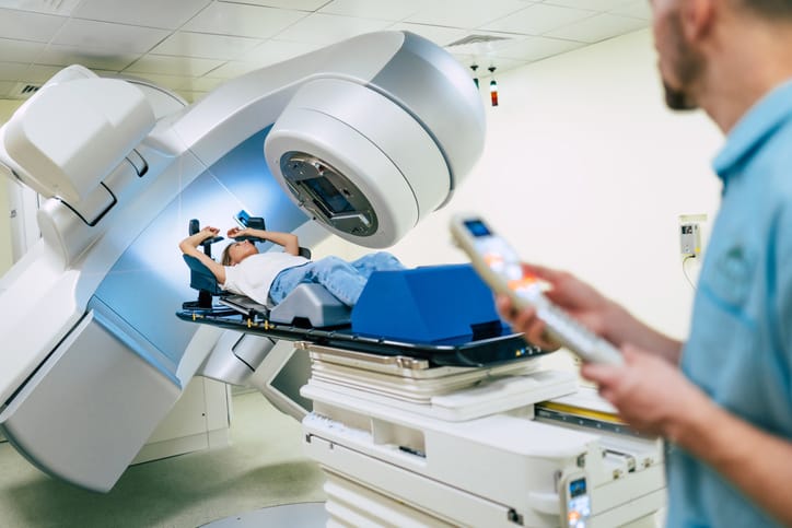 Photo shows a doctor workingwhile a patient is undergoing radiation therapy for cancer/Getty Images