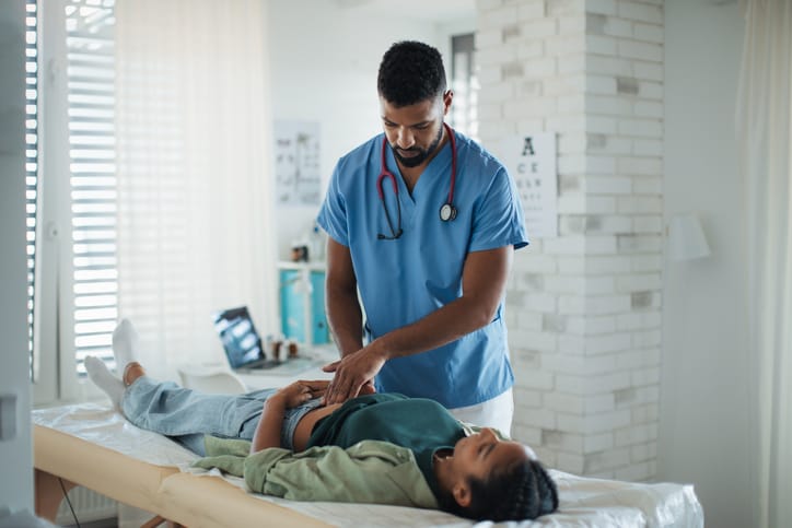 Photo shows a doctor examining a woman's abdomen/Getty Images