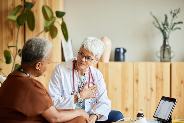 Photo shows a doctor speaking with a patient in her home/Getty Images
