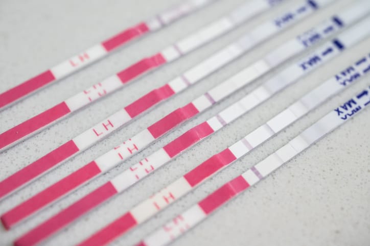 Photo shows several ovulation test strips lined up on a counter/Getty Images