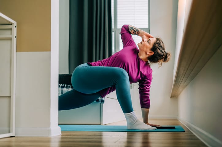 Photo shows a woman practicing yoga at home/Getty Images